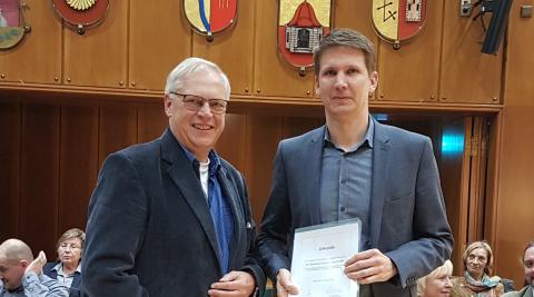 Dr. Ulrich Kumme überreicht Stefan Fischer das Zertifikat für das Gütesiegel.