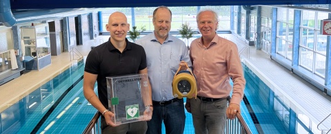 Clemens Steinmann (Mitte) übergibt den Defibrillator an Lukas Hahnsch (links) und Clemens Löcke.