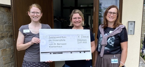 Karen Thiele (links) und Susann Börner (rechts) aus dem St. Bernward Krankenhaus überreichen Jeanne Golla 2000 Euro für die Vinzenzpforte.